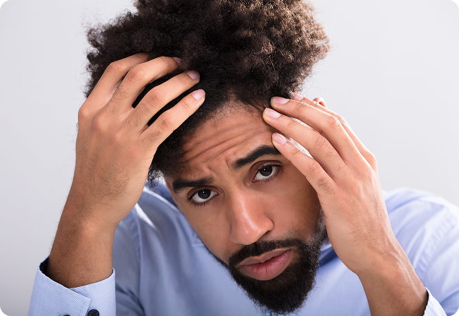Man examining his curly hair and hairline